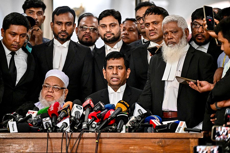 The International Crimes Tribunal Bangladesh (ICT) is preparing to try Sheikh Hasina. Photo: ICT Chief Prosecutor Mohammad Tajul Islam stands in the centre of a group of men in black suits, facing microphones, during a press conference.