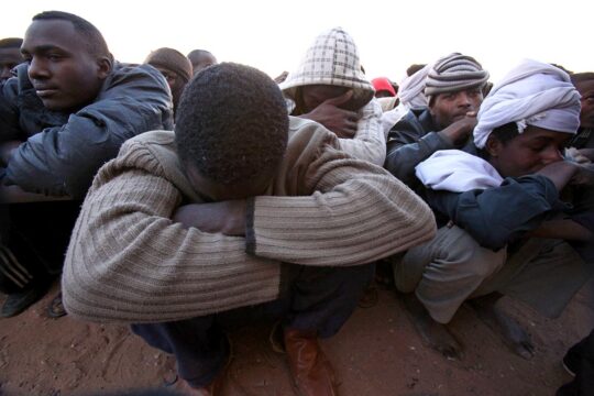 Walid's trial in the Netherlands for human trafficking in Libya. Photo: African migrants sit crammed together on the floor of a detention centre in Kufra, Libya.
